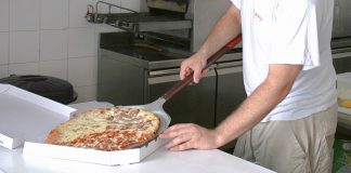 Un trabajador de un restaurante especializado en pizza