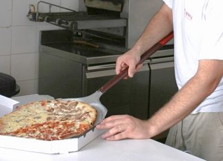 Un trabajador de un restaurante especializado en pizza
