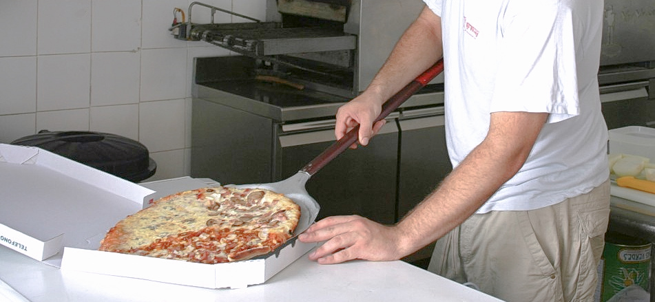 Un trabajador de un restaurante especializado en pizza